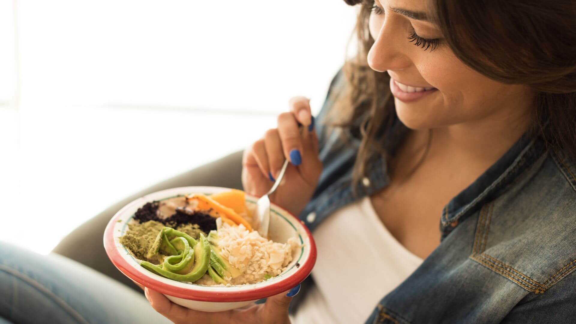 an image of a woman eating vegan diet in the article: Can I Eat Eggs on a Plant-Based Diet?